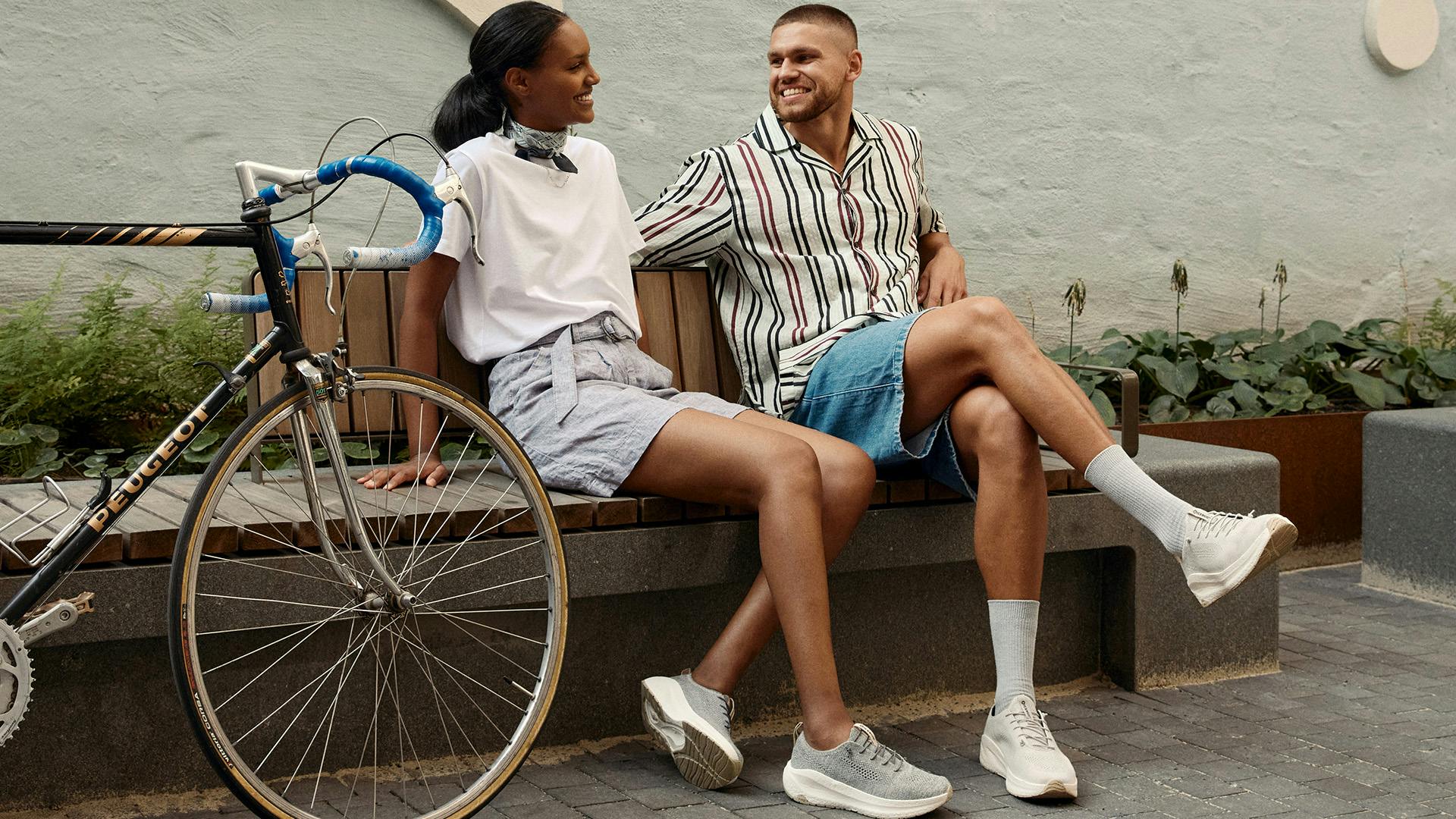 A couple enjoying a peaceful moment on a bench beside a bicycle.